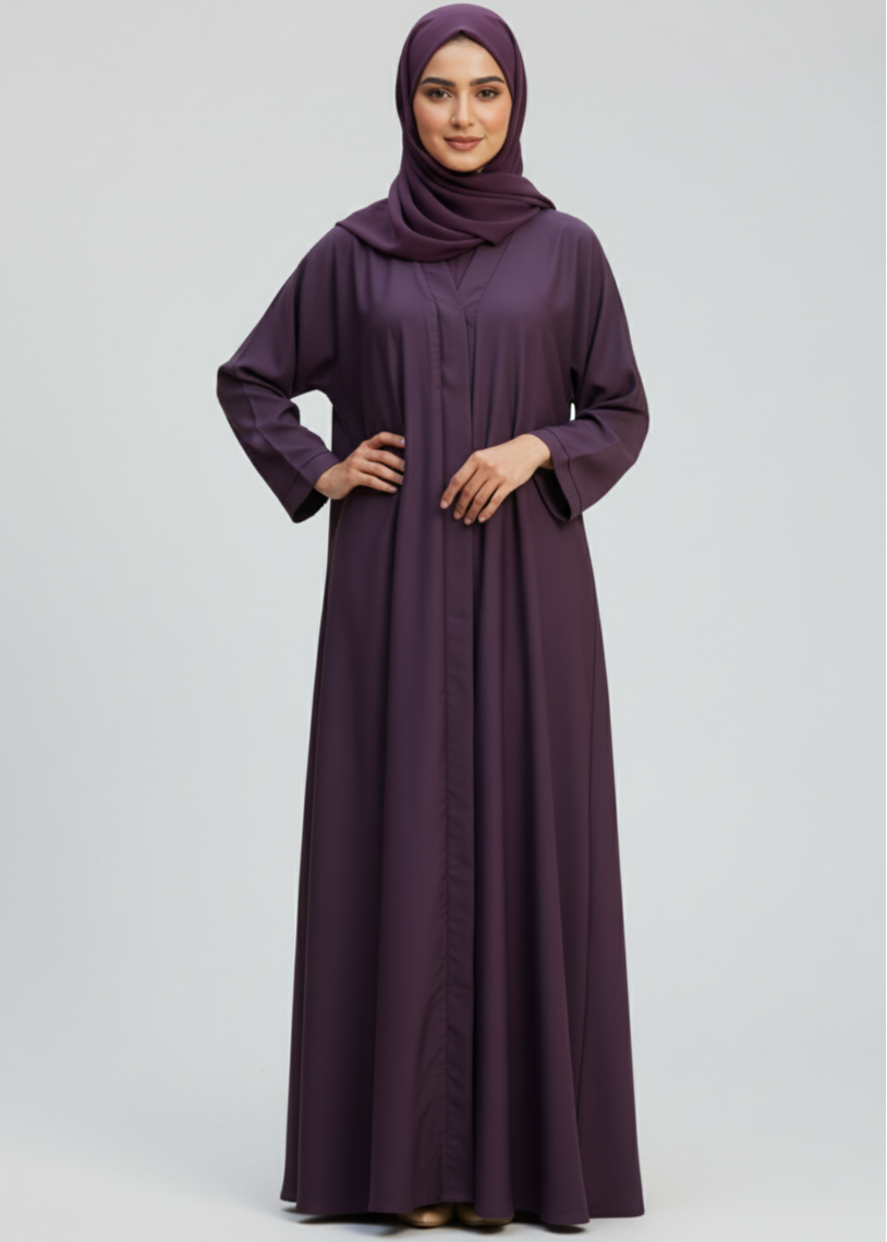 Woman wearing a long purple dress and hijab on a white background