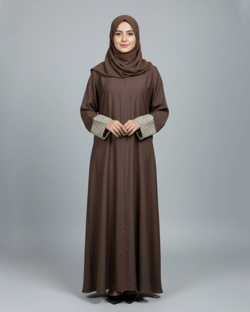 Woman wearing a brown abaya with a matching hijab on a gray background