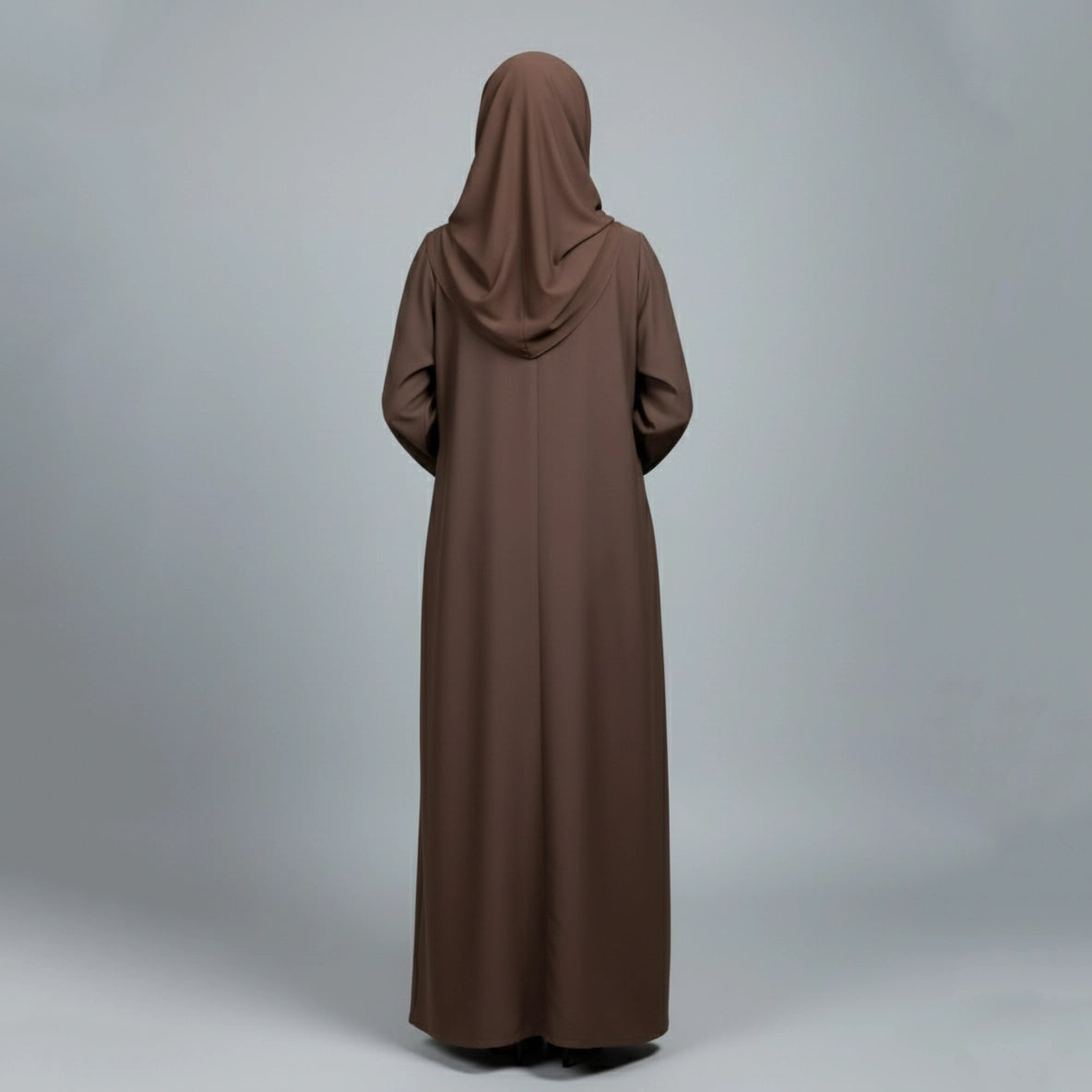 Brown abaya worn by a person on a gray background