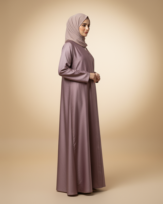 Woman wearing a long, light purple dress with a matching hijab on a beige background