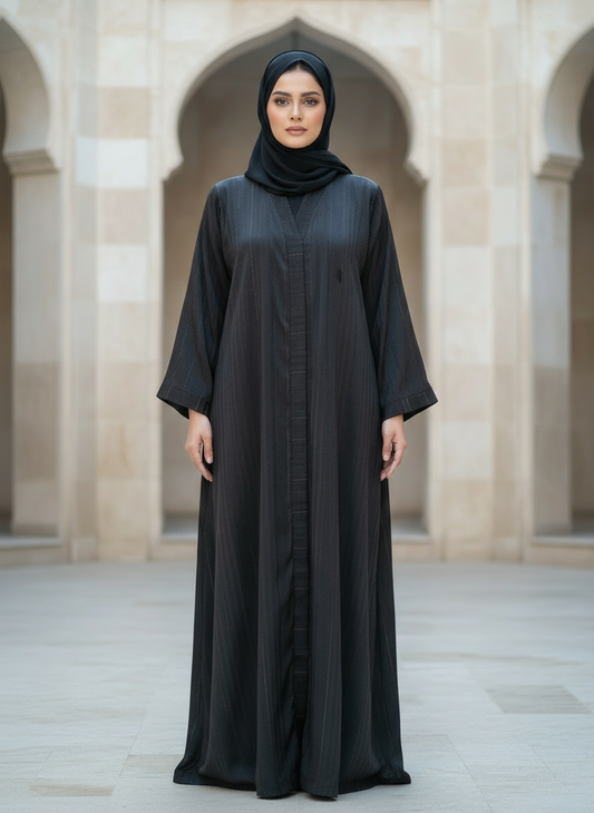 Woman wearing a black abaya in an arched architectural setting