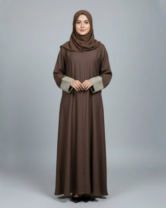 Woman wearing a brown abaya with a matching hijab on a gray background