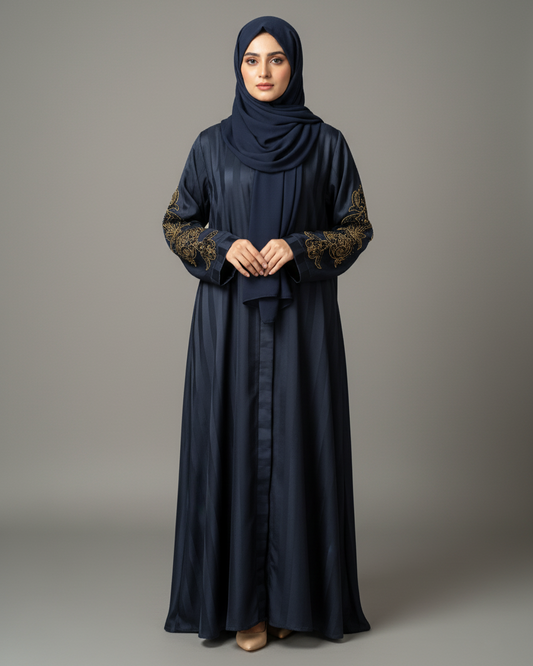 Woman wearing a dark blue abaya with floral patterns on a gray background